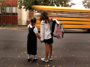 Two girls wait for a school bus in Montreal.