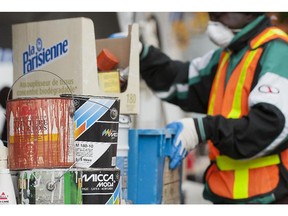 A workder sorts through varioius hazardous materials at a recycling drop-off point behind City Hall in Pointe Claire,