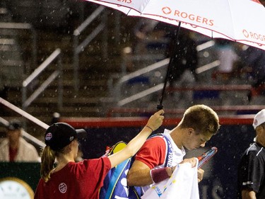 Borna Coric (CRO)  keeps his racket dry as he leaves the court for a rain delay during his match against Jo-Wilfred Tsonga (FRA) during Rogers Cup action in Montreal on Monday August 10, 2015.
