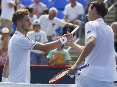 Canadian tennis player Filip Peliwo (left) shakes hands with Sergiy Stakhovsky of the Ukraine after the latter won their match at the Rogers Cup at Jarry Tennis stadium Monday, August 10, 2015.