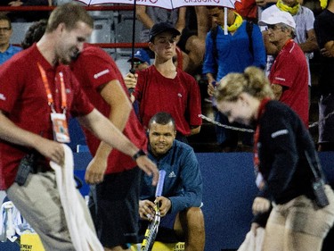 Jo-Wilfred Tsonga (FRA) watches as court personal try to dry the court after a rain delay during his match against Borna Coric (CRO) during Rogers Cup action in Montreal on Monday August 10, 2015. The match was called off after 2 rain delays.