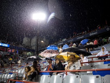 Tennis fans wait out a rain delay during the Borna Coric (CRO)  vs Jo-Wilfred Tsonga (FRA) match during Rogers Cup action in Montreal on Monday August 10, 2015.