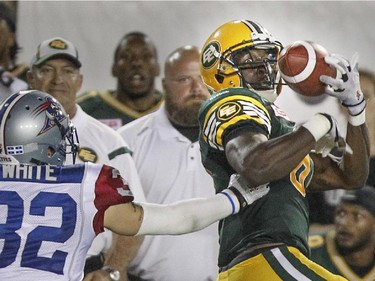 Edmonton Eskimos Devon Bailey catches a pass from quarterback James Franklin in front of Montreal Alouettes Mitchell White during Canadian Football League game in Montreal Thursday August 13, 2015.