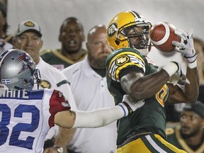 Edmonton Eskimos receiver Devon Bailey catches a pass from quarterback James Franklin in front of Alouettes defender Mitchell White during CFL game at Montreal's Molson Stadium on Aug. 13, 2015.