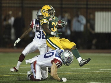 Edmonton Eskimos Shakir Bell is tripped up by Montreal Alouettes Marc-Olivier Brouillette (#10) during Canadian Football League game in Montreal Thursday August 13, 2015.