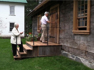 Judith Duncanson from the Paul Holland Knowlton House Committee, left,  watches architect David Kininmonth opening the door of the historic Paul Knowlton House. The house was saved from demolition last year and restored.It will open to the public for the first time on Saturday at its new home at the Brome County Historical Society Museum located in Knowlton,  an hour and a half drive from Montreal in the Eastern Townships.