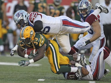Montreal Alouettes Corvey Irvin (#95) and Winston Venable (#31) team up to stop  Edmonton Eskimos Shakir Bell for a loss during Canadian Football League game in Montreal Thursday August 13, 2015.