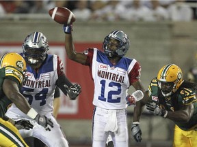 Alouettes quarterback Rakeem Cato dumps a pass off as he's pressured by Edmonton Eskimos defenders during CFL game at Montreal's Molson Stadium on  Aug. 13, 2015.