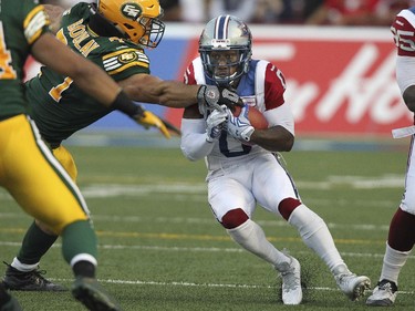 Montreal Alouettes kick returner Stefan Logan breaks a tackle by Edmonton Eskimos Mathieu Boulay during Canadian Football League game in Montreal Thursday August 13, 2015.