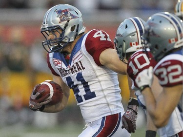 Montreal Alouettes linebacker Kyler Elsworth, left, leads team-mates Marc-Olivier Brouillette (#10) and Mitchell White to the endzone for a touchdown after intercepting pass by Edmonton Eskimos quarterback Matt Nichols during Canadian Football League game in Montreal Thursday August 13, 2015.