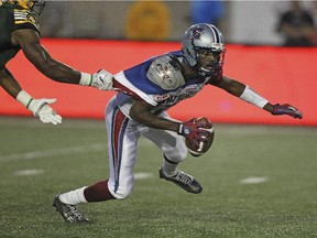 Montreal Alouettes quarterback rakeem Cato is grabbed by Edmonton Eskimos Odell Willis during Canadian Football League game in Montreal Thursday August 13, 2015.