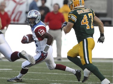 Montreal Alouettes quarterback Rakeem Cato runs away fromEdmonton Eskimos JC Sherritt during Canadian Football League game in Montreal Thursday August 13, 2015.