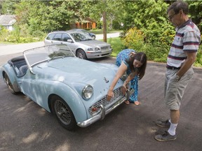 Gary Grant, right, discusses the 1961Triumph TR3A with his daughter Nissa in the driveway at his home in Beaconsfield. Nissa gave him 100 hours of labour last Christmas which she used to rebuild the classic car with him.