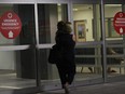 A woman carries a child as she walks into the emergency room of the Montreal Children's Hospital.