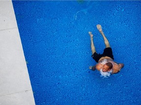 MONTREAL, QUE.: AUGUST 18, 2015 -- Eric Gravelle swims on a rooftop pool at a condo building in Griffintown during a hot summer day in Montreal on Tuesday, August 18, 2015. With temperatures reaching 30 degrees Celsius (39 degrees with humidex), the heatwave caused a heat alert to be issued for the region of Montreal. (Dario Ayala / Montreal Gazette)