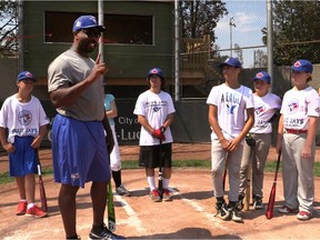 Former Toronto outfielder Devon White gives instructions to young players attending the Blue Jays Academy at Gary Carter Field in Montreal on Aug. 19, 2015.
