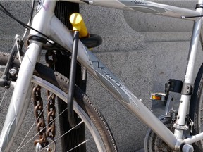 A bicycle is locked to a parking meter pole.