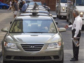Montreal taxis and drivers, wait in line in front of Place Ville-Marie on Cathcart St. on Thursday Aug. 20, 2015.