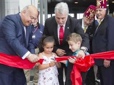 Shriners Hospital patients Marie-Pierre Paquette and Carter Brown perform a ribbon-cutting ceremony for the opening  of the new $127-million Shriners Hospital for Children Thursday, August 20, 2015 with the help of Quebec premier Philippe Couillard (centre) and Robert Poëti, Minister of Transport and Minister responsible for the Montréal region. On the far right is Dale Stauss, Chairman of the Board of Trustees Shriners Hospitals for Children and Jerry Gant, Imperial Potentate Shriners.