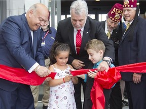 Shriners Hospital patients Marie-Pierre Paquette and Carter Brown perform a ribbon-cutting ceremony for the opening  of the new $127-million Shriners Hospital for Children Thursday, August 20, 2015 with the help of Quebec premier Philippe Couillard (centre) and Robert Poëti, Minister of Transport and Minister responsible for the Montréal region. On the far right is Dale Stauss, Chairman of the Board of Trustees Shriners Hospitals for Children and Jerry Gant, Imperial Potentate Shriners.