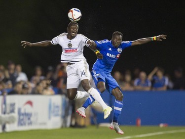 Ambroise Oyongo of the Montreal Impact (right) and Eric Ayuk Mbe of the Philadelphia Union battle for the ball in M.L.S. action at Saputo Stadium in Montreal Saturday, August 22, 2015.