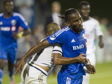 Didier Drogba, making his debut for the Montreal Impact, is tackled by Fabinho of the Philadelphia Union in M.L.S. action at Saputo Stadium in Montreal Saturday, August 22, 2015.