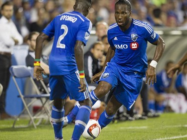 Didier Drogba (right) looks toward teammate Ambroise Oyongo in his debut for the Montreal Impact against the Philadelphia Union in M.L.S. action at Saputo Stadium in Montreal Saturday, August 22, 2015.
