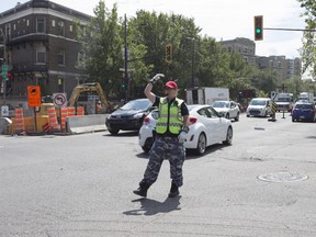 Constable Stephanie Le Lan directs traffic at the intersection of Sherbrooke St. and Papineau Ave. in Montreal, Monday Aug. 24, 2015.