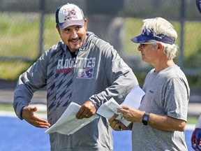 Alouettes head coach and general manager Jim Popp, right, listens to  quarterbacks coach Anthony Calvillo during practice in Montreal Monday, Aug. 24, 2015.