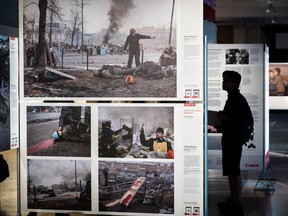 A man looks at photos from the 2015 World Press Photo exhibition at Bonsecours Market in Montreal on Tuesday, Aug. 25, 2015.