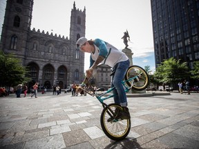 Kirkland's Jean William Prévost, organizer of this weekend's RealCitySpin event, performs a trick on his BMX bike at Place d'Armes on Aug. 26, 2015. (Dario Ayala / Montreal Gazette)
