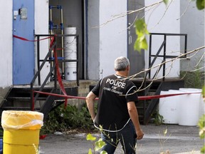 Police investigators work outside a warehouse suspected of being a drug lab used for manufacturing fentanyl in Dorval on Saturday, August 29, 2015.