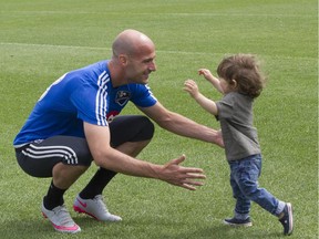 Impact star defender Laurent Ciman opens his arms to greet his 1-year-old son, Achille, after practice in Montreal on Aug. 3, 2015.