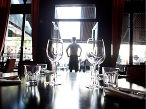 A waiter watches out over the terrace from the main dining room at Harlow Supper Club in Montreal on Tuesday August 4, 2015.
