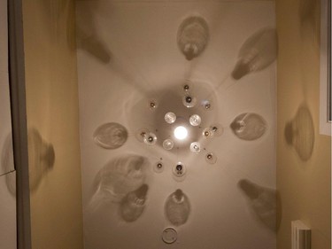 A straight-up look at a 'chandelier' made of light bulbs created by Anna Delfino in the entrance area of her apartment.