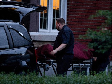 Cheryl Bau-Tremblay's body is loaded into a morgue truck after Sureté du Québec police searched her home in Beloeil near Montreal on Thursday August 6, 2015.