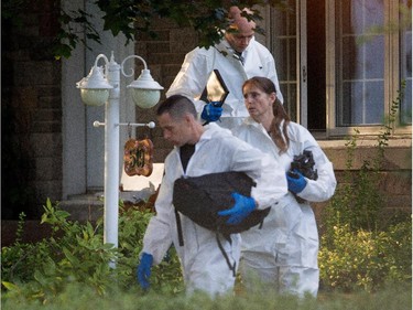 Sureté du Québec police investigators take a short break as they search the home of Cheryl Bau-Tremblay after her body was found inside the Beloeil home near Montreal on Thursday August 6, 2015.