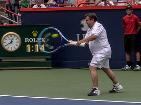 Montreal mayor Denis Coderre tries to return serve from Canadian tennis star Milos Raonic during Rogers Cup event at Jarry Tennis Stadium on Aug. 7, 2015.