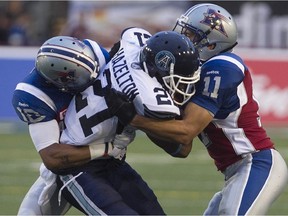MONTREAL, QUE.: JUNE 18, 2015 -- Montreal Alouettes Chip Cox, right, and Geoff Tisdale, bring down Toronto Argonauts Vidal Hazelton, during pre-season CFL football action in Montreal on Thursday June 18, 2015. (Pierre Obendrauf / MONTREAL GAZETTE)
