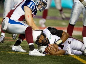 Ottawa Redblacks quarterback Henry Burris hits the turf to avoid being sacked by Alouettes safety Marc-Olivier Brouillette during CFL game at Montreal's Molson Stadium on June 25, 2015. The Redblacks won the game 20-16.