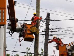 Hydro Quebec linesmen replace a broken pole and transfer the power lines May 26, 2015.