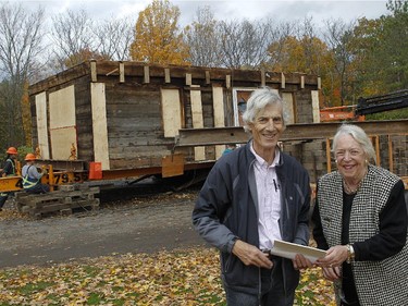 Judith Duncanson, right, president of Paul Holland Knowlton committee and architectural consultant David Kininmonth, left,  are standing in front the1815 Knowlton House, in Knowlton, a small town, one hour east of Montreal. It will be loaded onto a truck and moved to the Brome County Museum on Friday night at 6 p.m on October 17, 2014.The house has been stripped down to the original log cabin.They have taken off the roof so it won't bump into hydro lines while being moved. It will be reconstructed on a new foundation and turned into a museum.