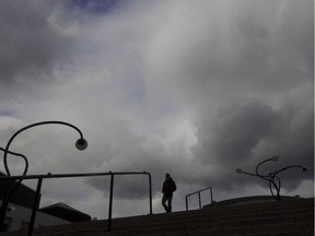 Storm clouds gather over downtown Montreal, Thursday, October 9, 2014, as a pedestrian strolls past Place des Arts.