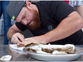 Eamon Clark of Toronto puts his knife to a dozen oysters during a shucking competition at the Montreal Oysterfest  in 2014.