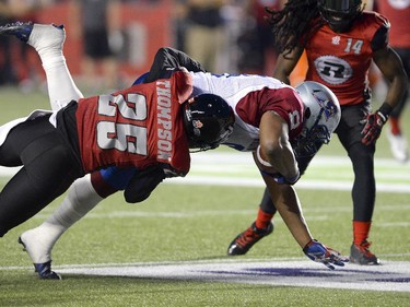 Ottawa Redblacks' Brandyn Thompson (25) takes down Montreal Alouettes' Nik Lewis (8) during the first half of a CFL game in Ottawa on Friday, Aug. 7, 2015.