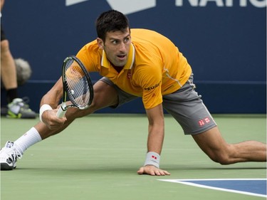 Novak Djokovic, of Serbia, slips after returning to Jeremy Chardy, of France, during the semifinals at the Rogers Cup tennis tournament on Saturday, August 15, 2015, in Montreal. Djokovic won 6-4, 6-4 to move on to the final.