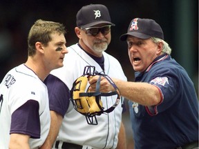 The Tigers' Dean Palmer (left) continues to argue with home-plate umpire Jim McKean as manager Larry Parrish holds him back during game against the Kansas City Royals on July 22, 1999, in Detroit. Palmer was ejected from the game.