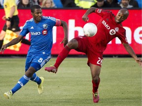The Impact's Patrice Bernier (left) battles for ball with Toronto FC's Collen Warner during Canadian Championship game in Toronto on May 13, 2015.