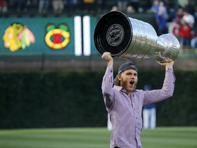 The Chicago Blackhawks' Patrick Kane carries the Stanley Cup before baseball game between the Chicago Cubs and Cleveland Indians at Wrigley Field on June 16, 2015.