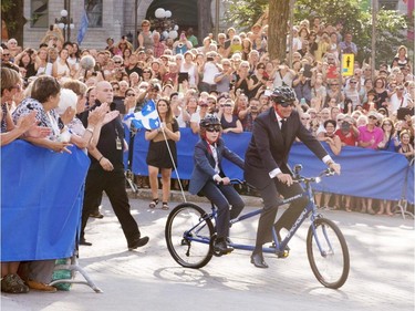 Parti Québécois Leader Pierre-Karl Peladeau and his son, Thomas, arrive on a tandem bicycle to get married to Julie Snyder, Saturday, August 15, 2015, in Quebec City.